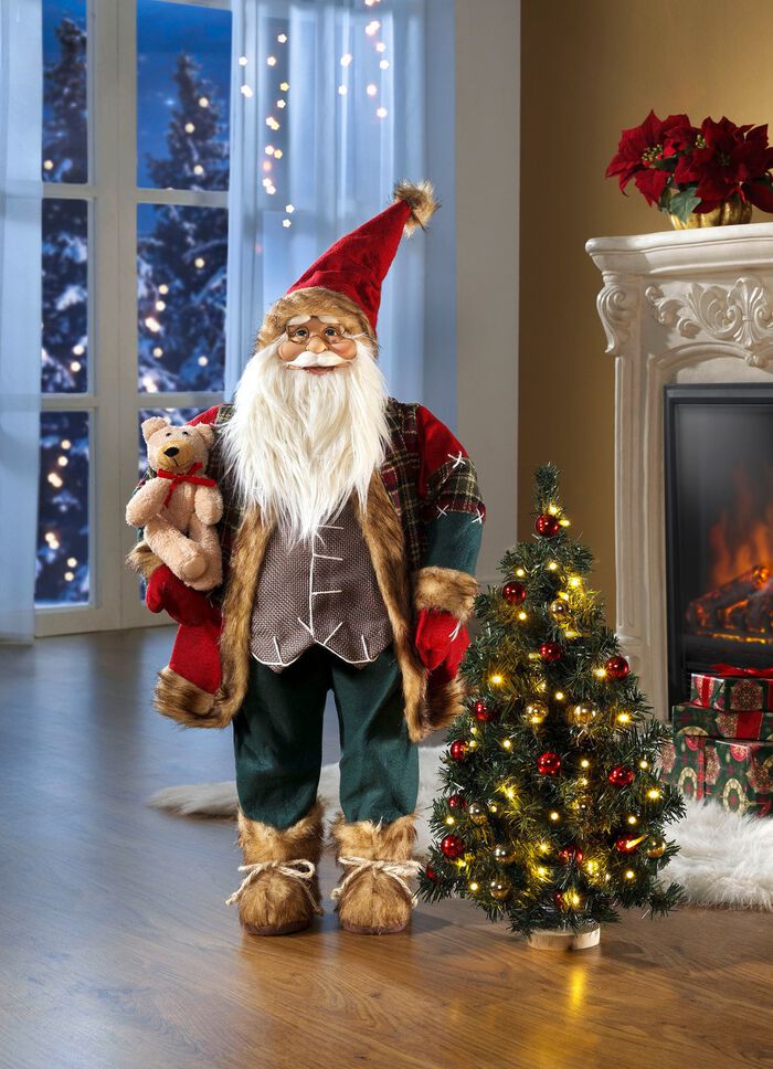 Weihnachtsmann mit beleuchtetem Weihnachtsbaum 