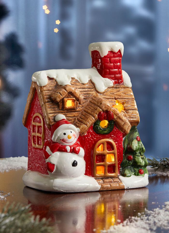 Beleuchtetes Haus mit Schneemann 